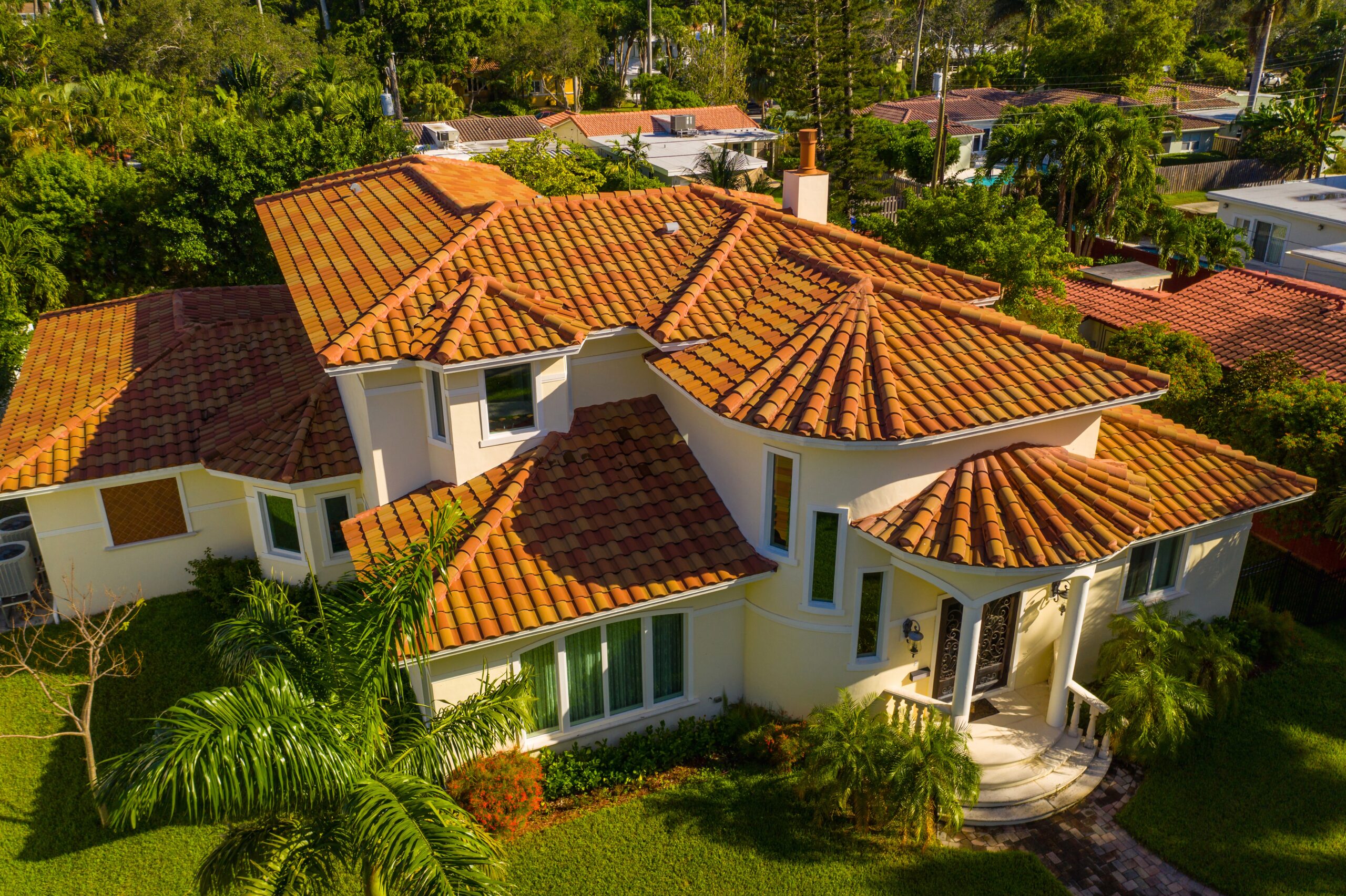 Aerial drone image of a luxury Florida home's roof with palm trees