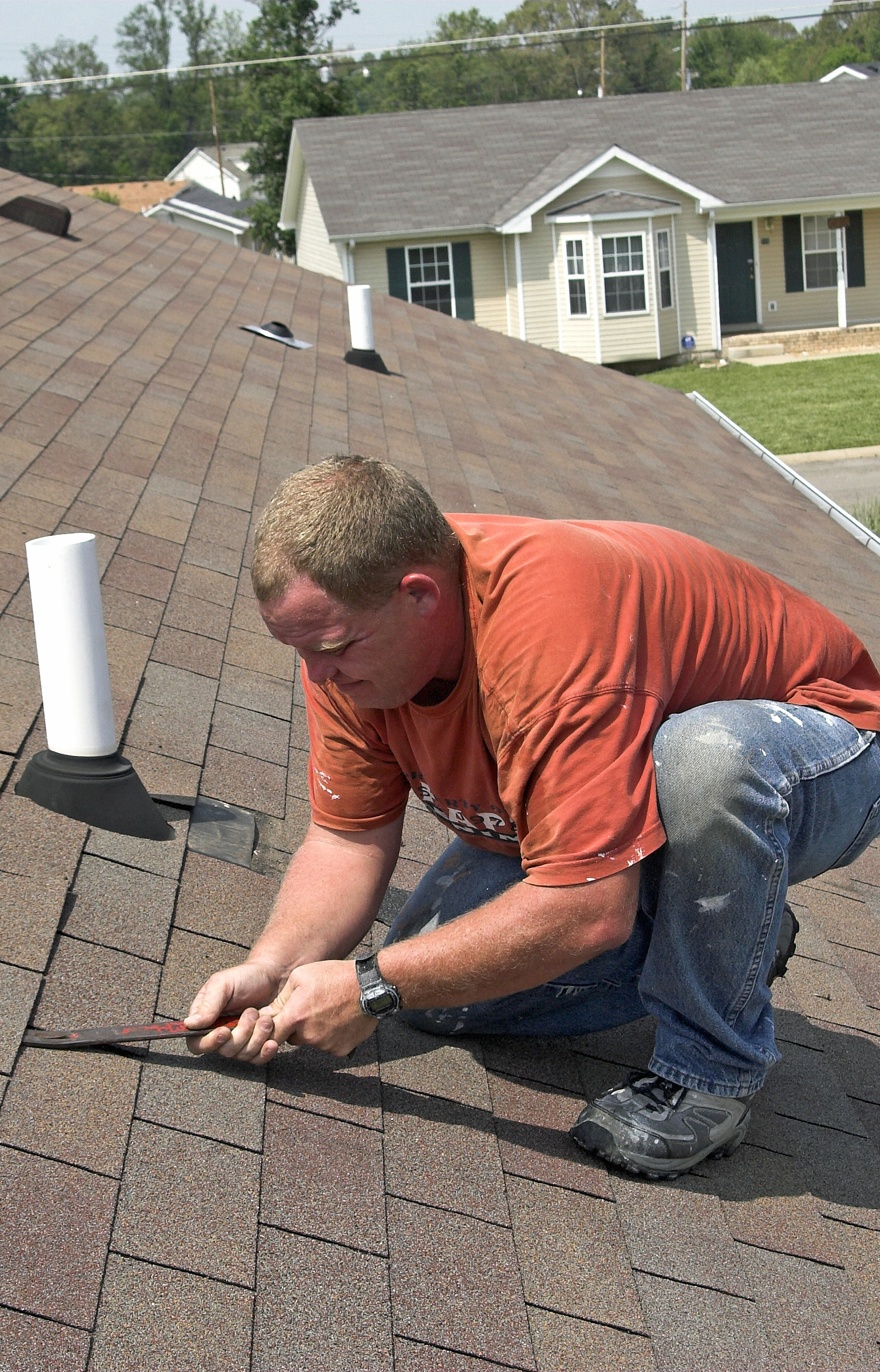 Roofer checking damaged shingles after storm with very high winds came through over night